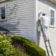 Professional painters in Auckland repainting an exterior home damaged by weather conditions