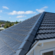Freshly painted residential roof in Auckland with durable protective coating under clear blue skies